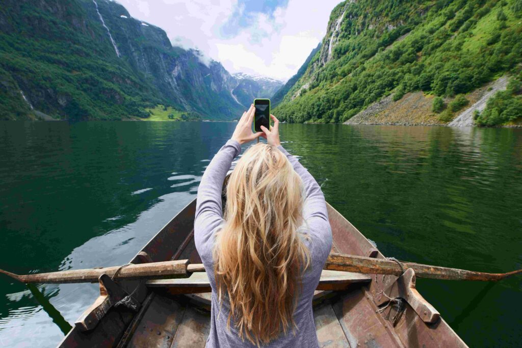 adventure woman in row boat taking photo on smart 2022 12 08 21 56 19 utc