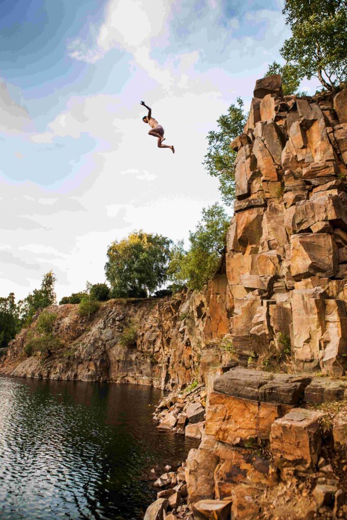 low angle view of man jumping in lake against sky 2022 02 02 03 57 07 utc